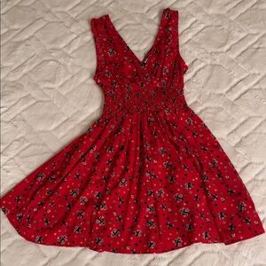 Feminine, flowy, and easy red dress with defined waist band and fine print.
